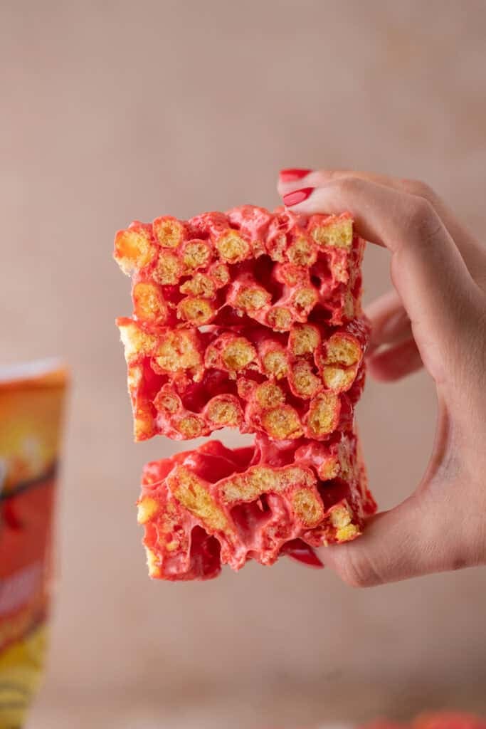 Hot Cheetos Marshmallow Crispy Treats recipe held up by a hand