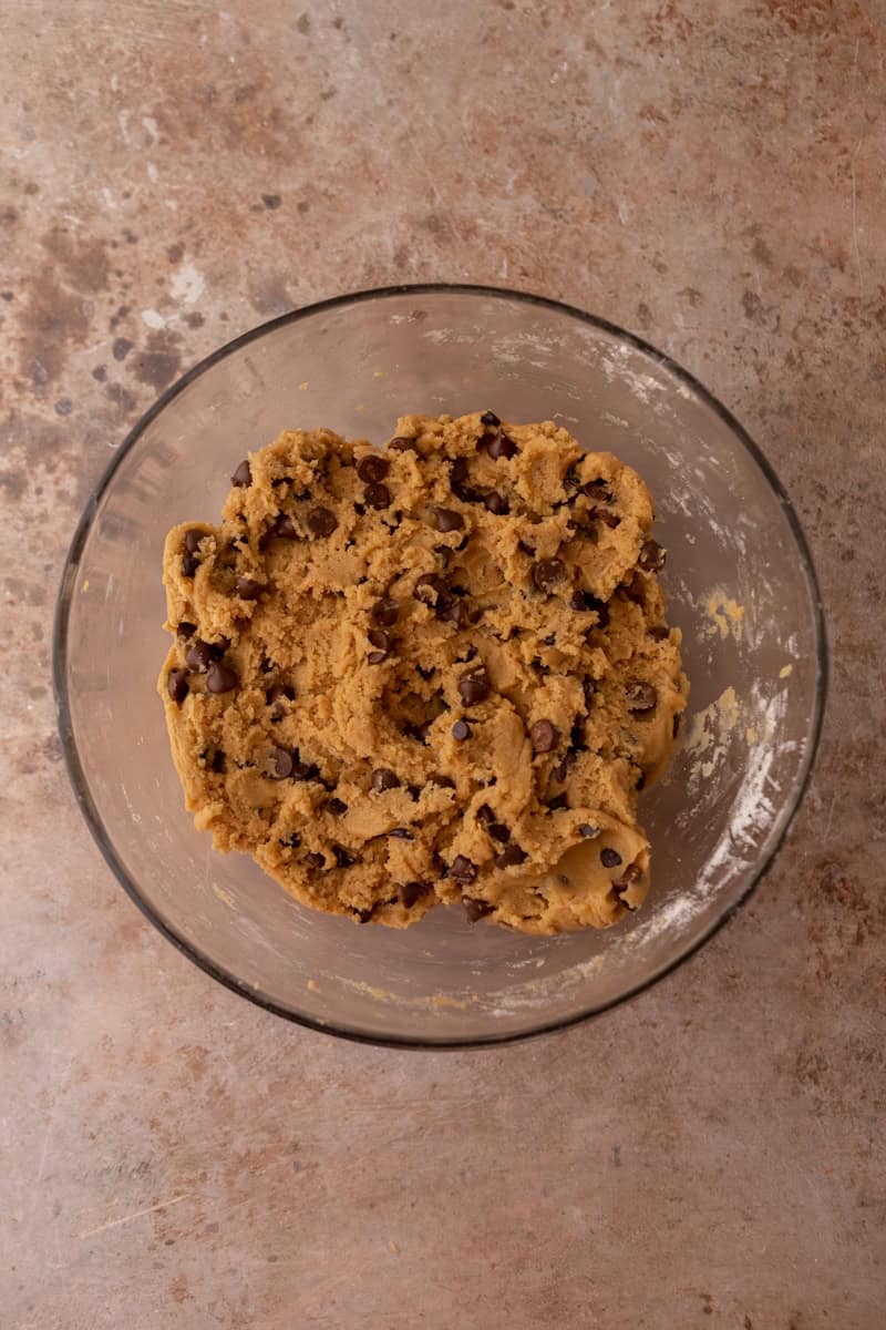 Mixed peanut butter chocolate chip cookie dough in a glass bowl.