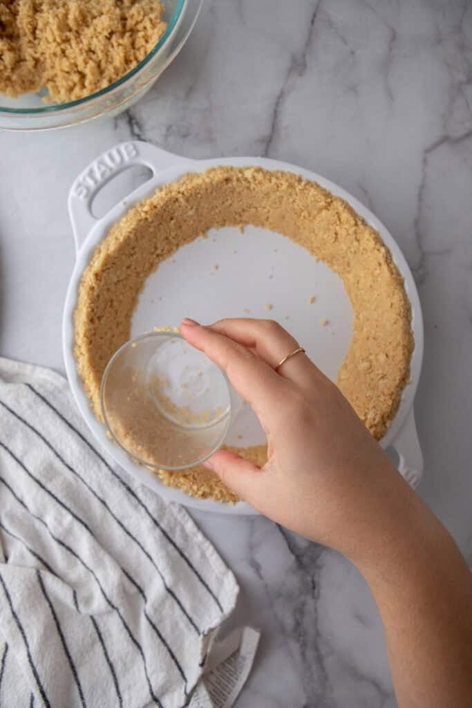 crumbs being shaped into a pan