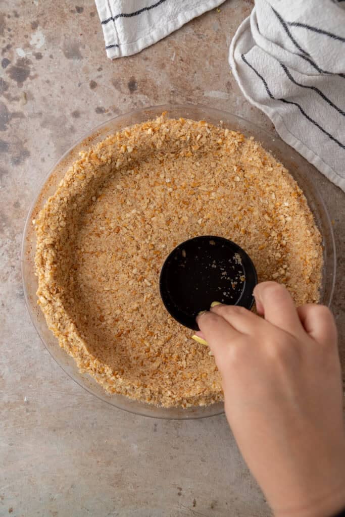 crumbs being pressed into a pan