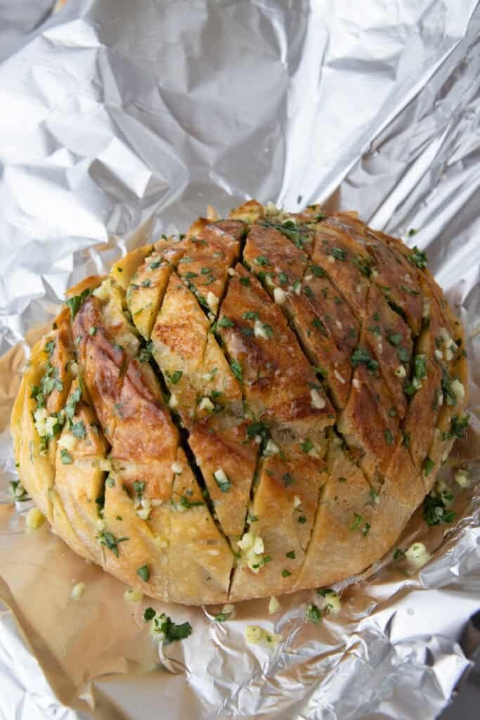 Sourdough loaf stuffed with garlic and wrapped in foil before baking