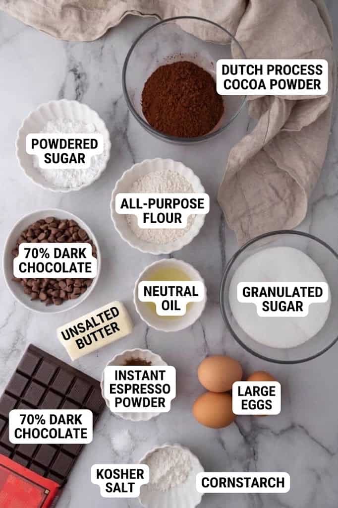 Butter, dark chocolate, cocoa powder, eggs, sugar, flour and cornstarch measured out in bowls.