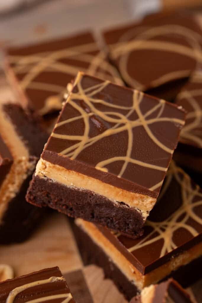 Buckeye brownies showing three distinct layers of fudgy brownie base, smooth peanut butter filling, and chocolate ganache with peanut butter drizzle on top