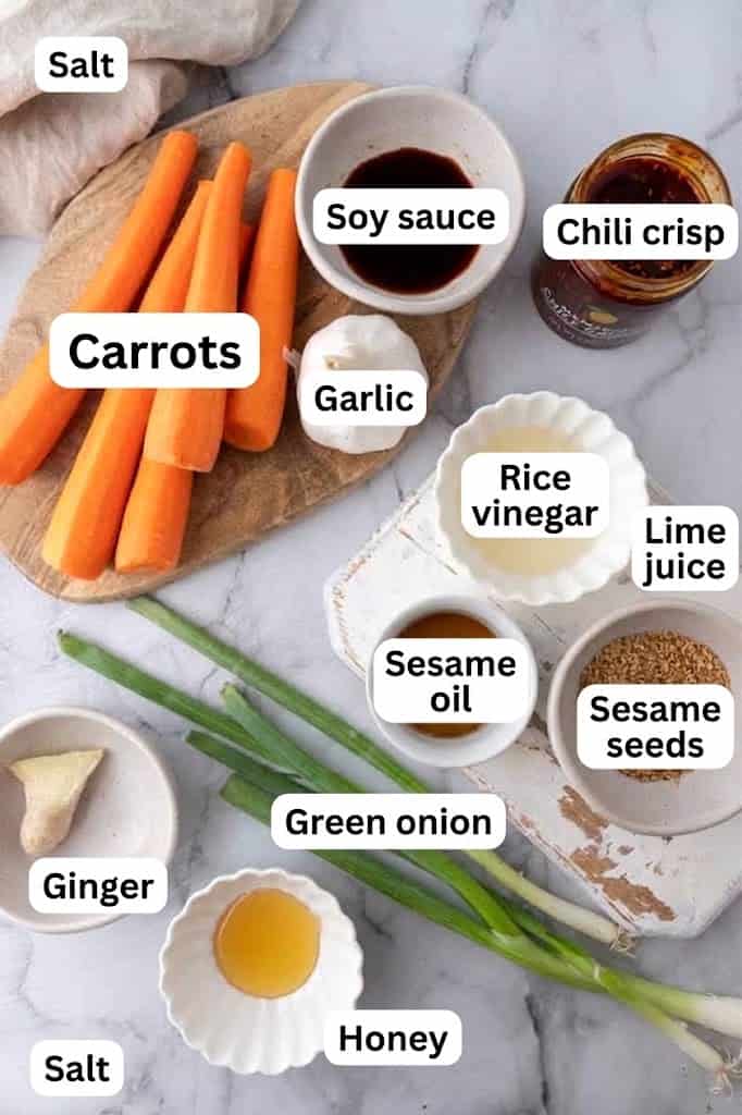 Ingredients for carrot ribbon salad including carrots, rice vinegar, soy sauce, sesame oil, and chili crunch.