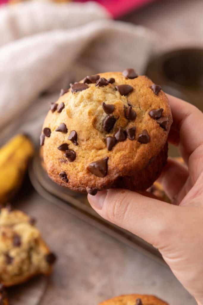 Banana Chocolate Chip Muffins held up by a hand