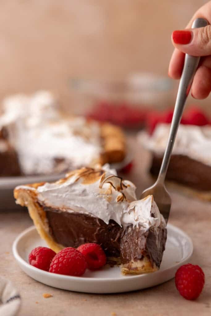 chocolate meringue pie slice with a fork going in
