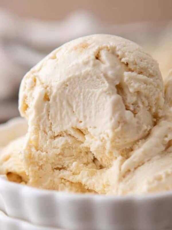 Two scoops of no-churn cream cheese ice cream in stacked white ribbed bowls.
