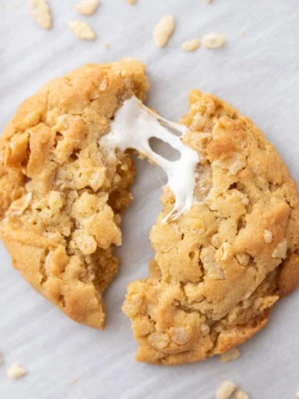 A Costco Marshmallow Crispy Cookie split in half with a melty marshmallow pulled and stretched between the two halves.