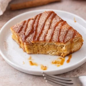 Churro Pumpkin cheesecake bars on a plate with a bite taken out