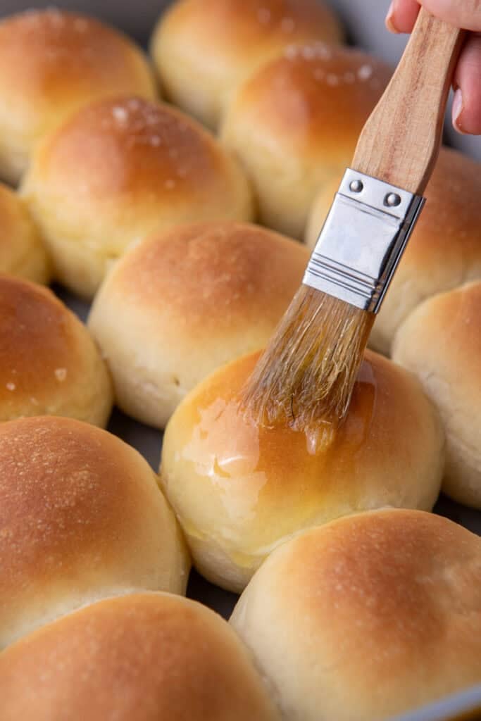Brushing the dinner rolls with melted butter