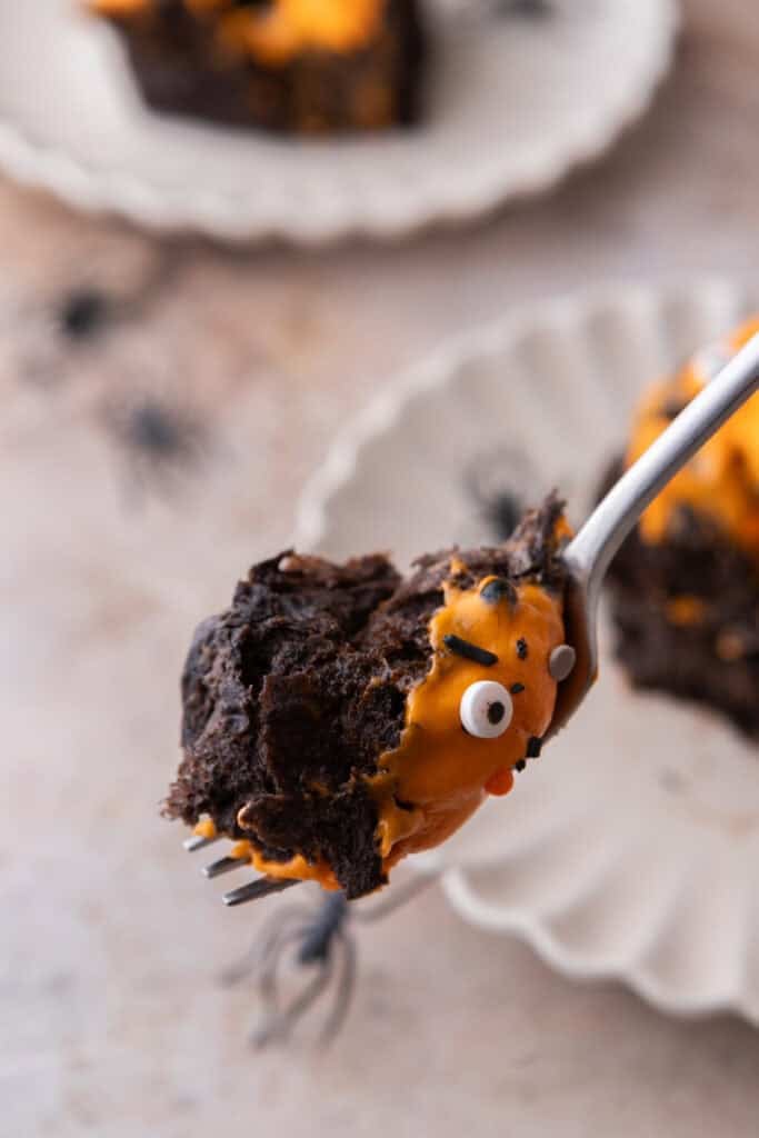 Black Cocoa Cinnamon Rolls with a bite on a spoon