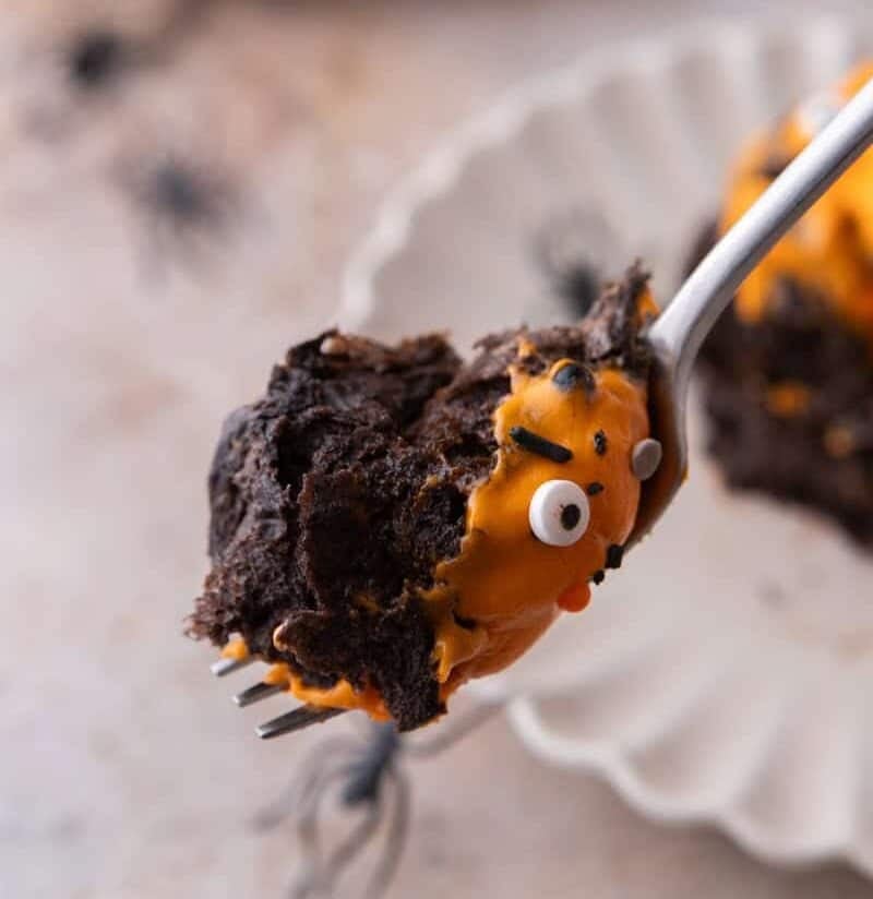 Black Cocoa Cinnamon Rolls with a bite on a spoon