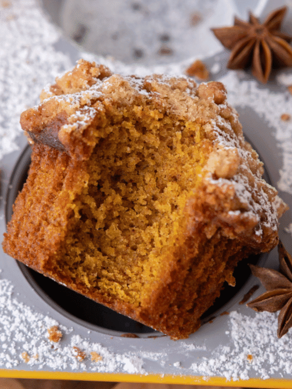 Copycat Panera Bread pumpkin muffin with a bite taken out, showing fluffy, moist crumb and sweet streusel topping