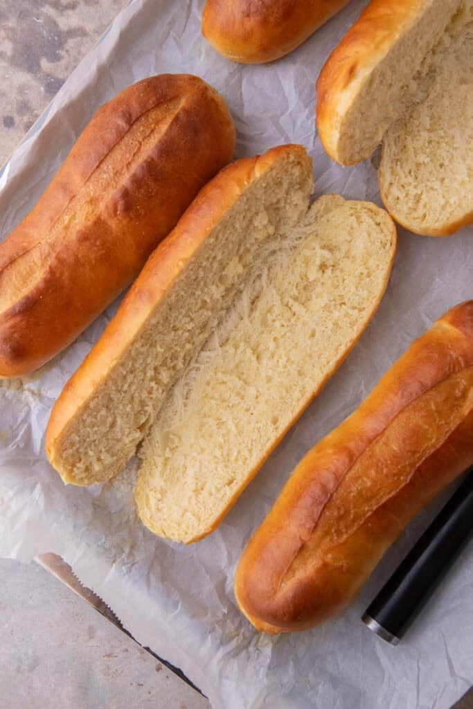 homemade hoagie roll recipe split in half on a baking sheet.