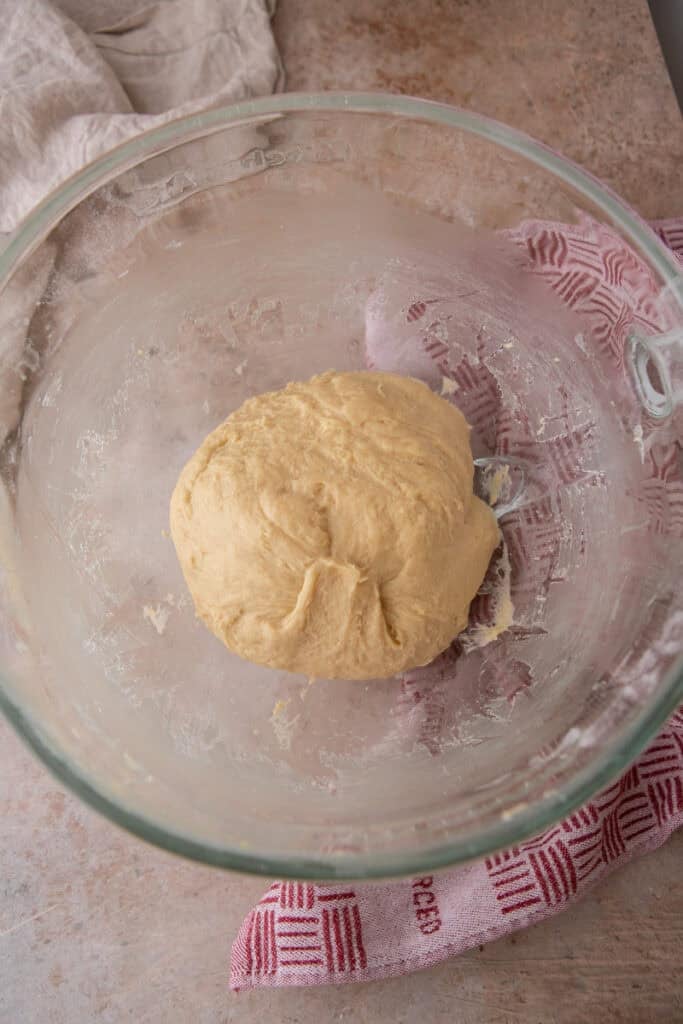 Smooth, elastic hoagie roll dough after mixing in a glass bowl.