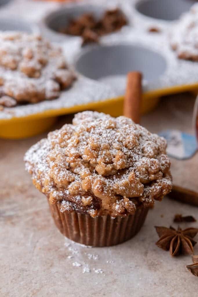 Panera Bread Pumpkin Muffin next to muffin tin on the counter.
