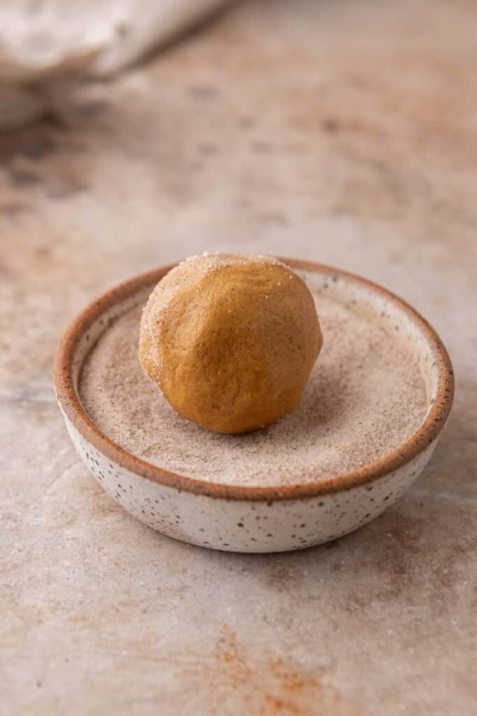 raw dough getting rolled in sugar