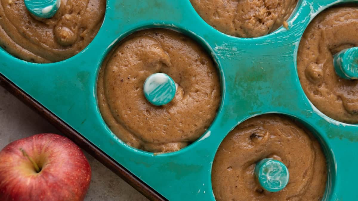 Batter piped into a deep-well donut pan before baking.
