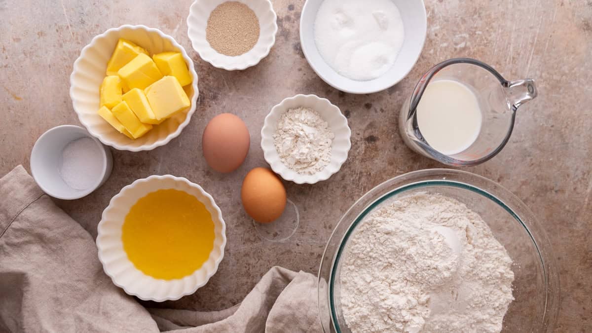 Ingredients for brioche dough including flour, butter, eggs, yeast, and milk