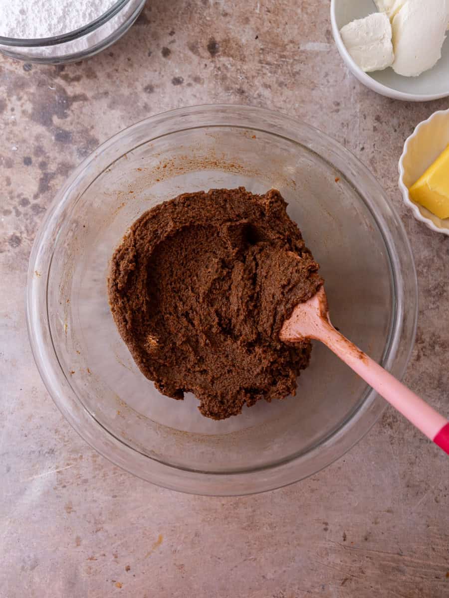 Cinnamon roll brown sugar cinnamon filling in a glass bowl with spatula.