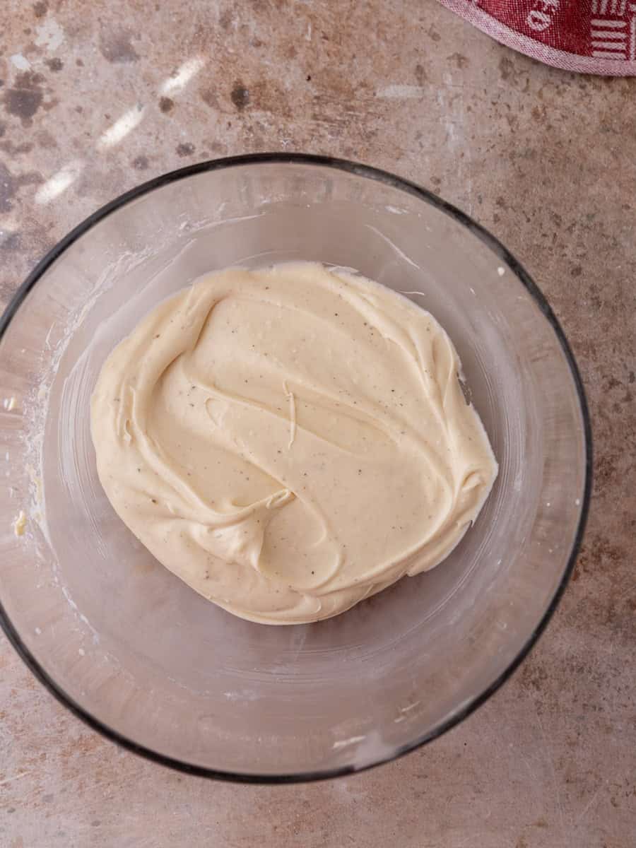 Cream cheese cinnamon roll frosting in a glass bowl, whipped smooth and fluffy
