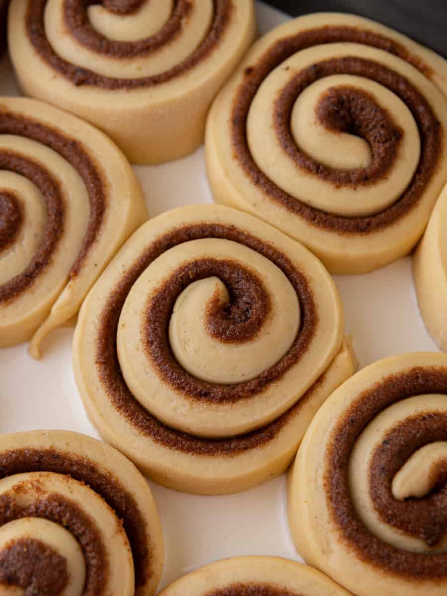 Unbaked brioche cinnamon rolls arranged in a baking pan