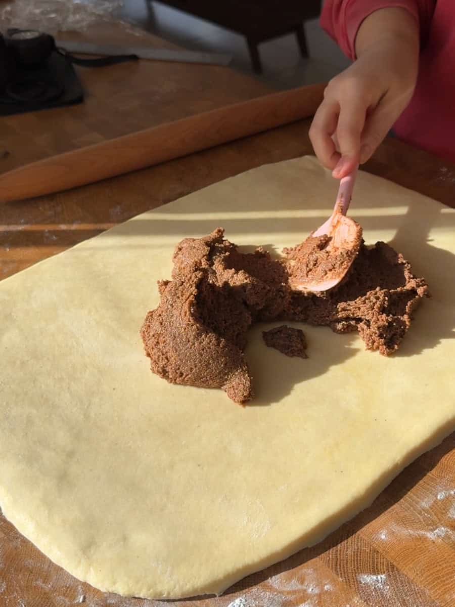  Spreading cinnamon filling over rolled brioche dough