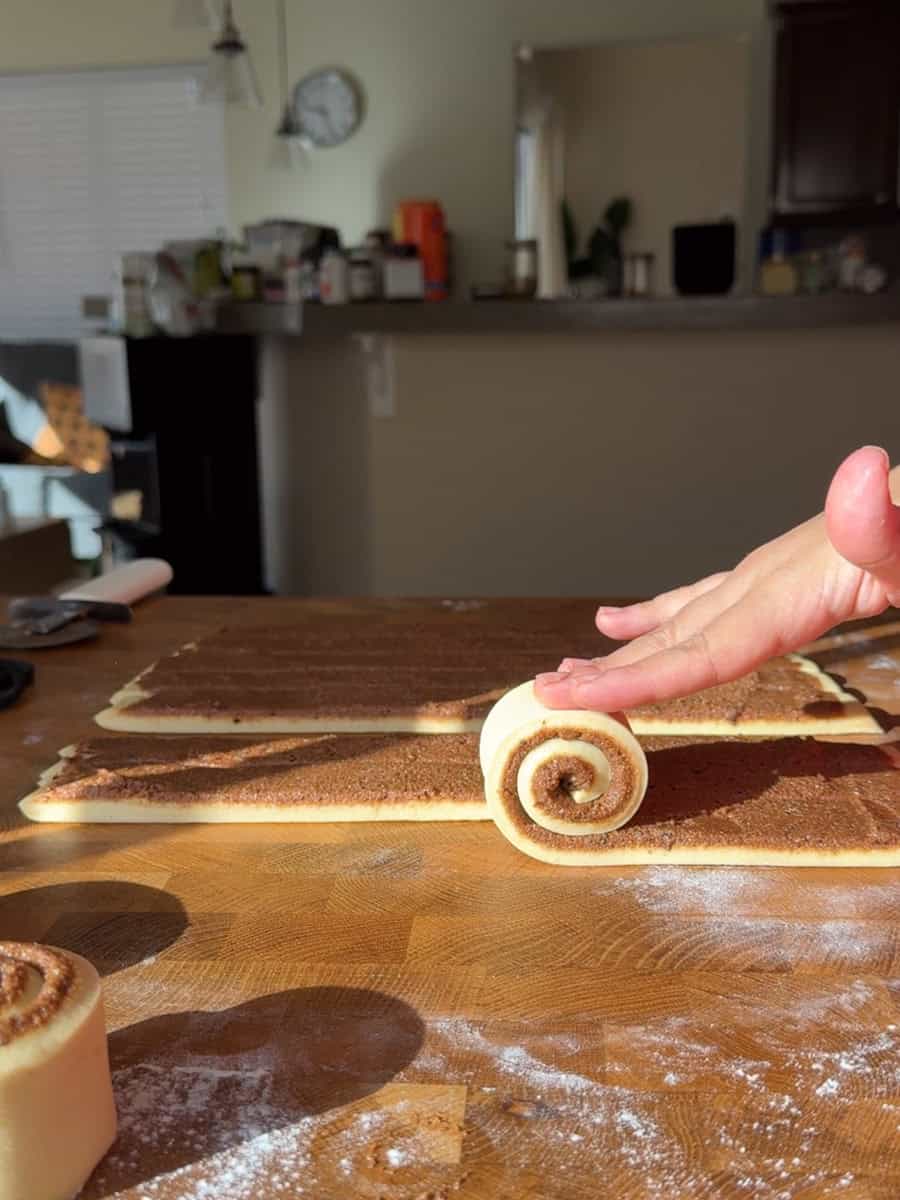 Cinnamon roll dough cut into even strips before shaping
