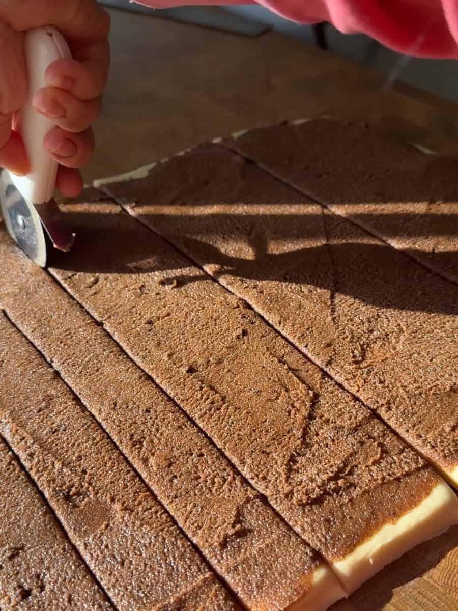 Spreading cinnamon filling over rolled brioche dough