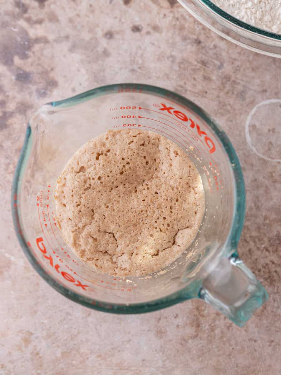 Activated yeast mixture bubbling in glass measuring cup