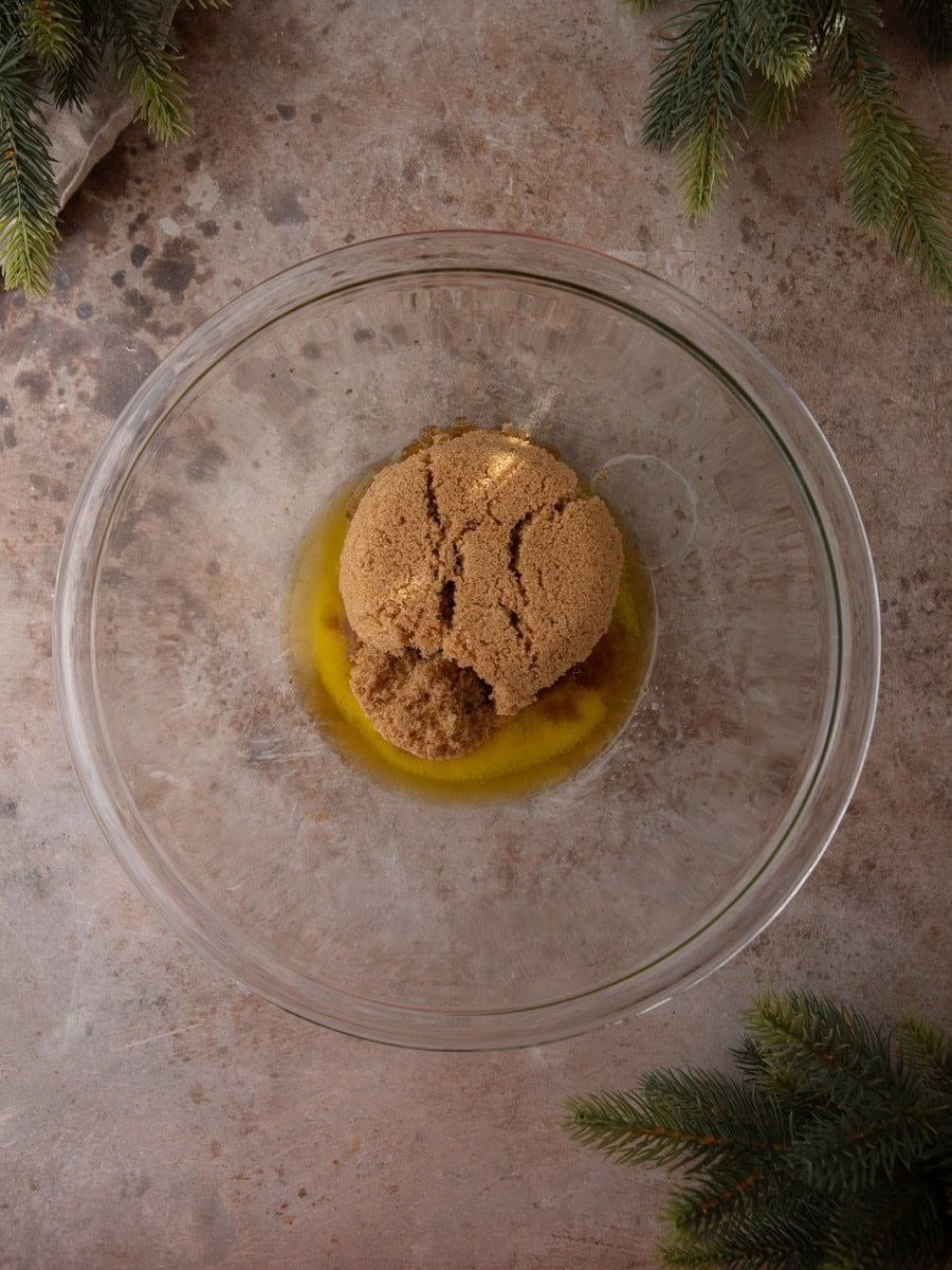 Melted butter and packed brown sugar in a glass mixing bowl before combining.