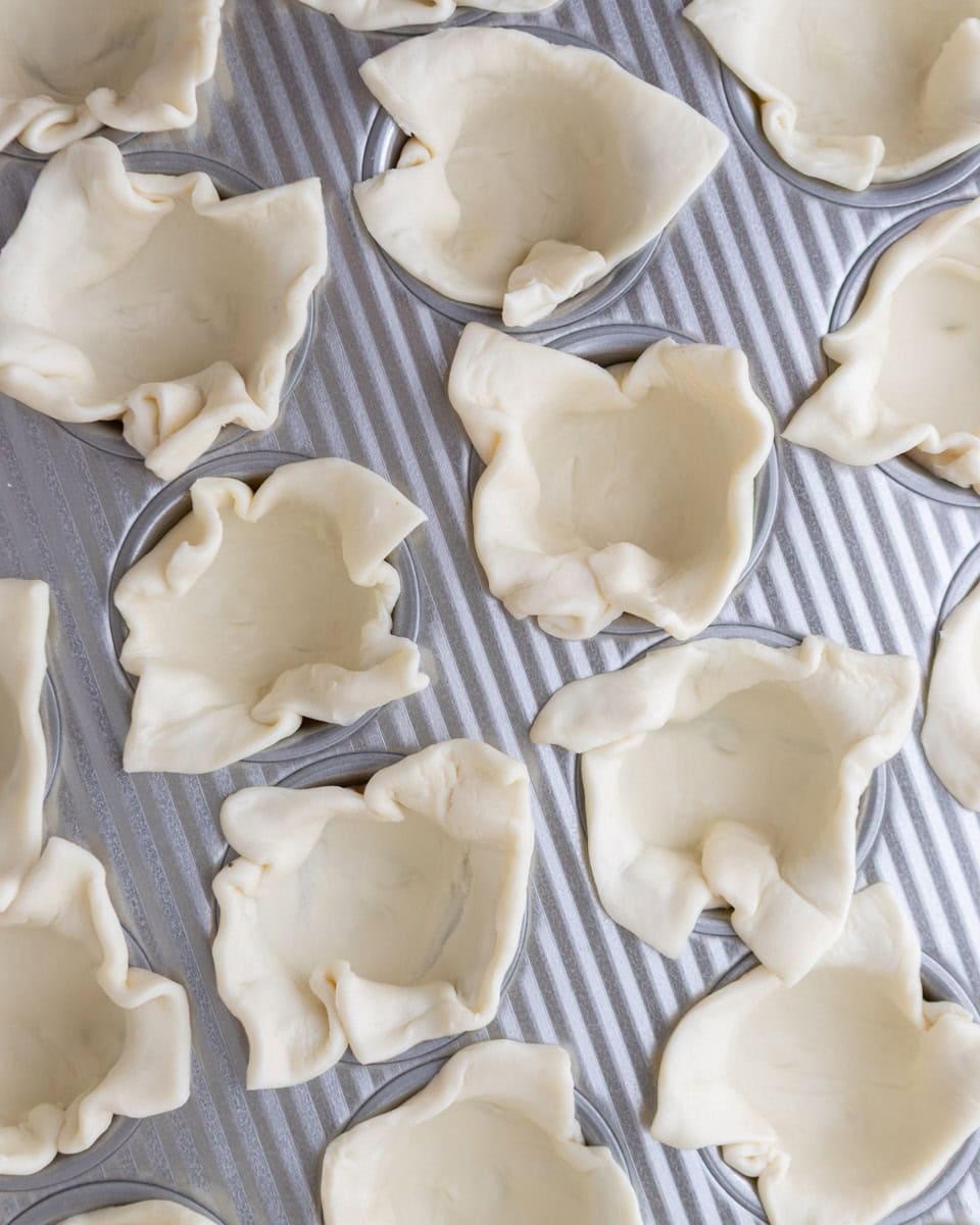 Puff pastry pressed into a mini muffin tin to form cups