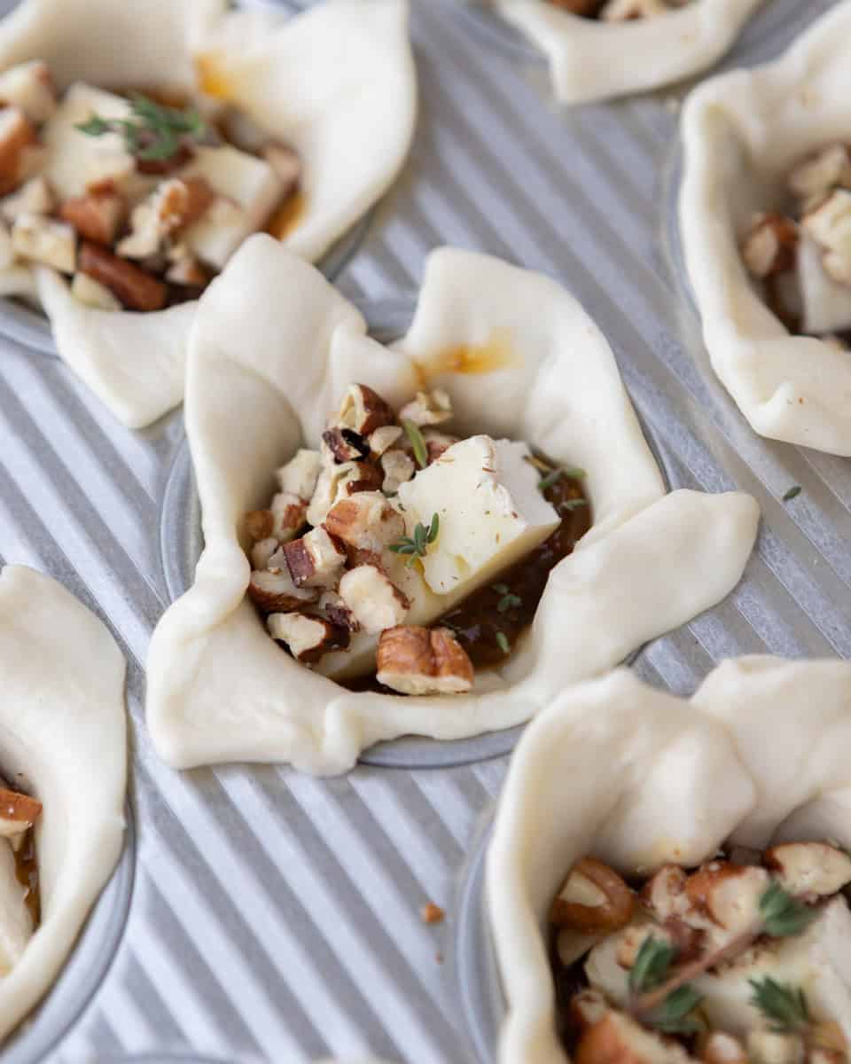 Unbaked puff pastry cups filled with pecans