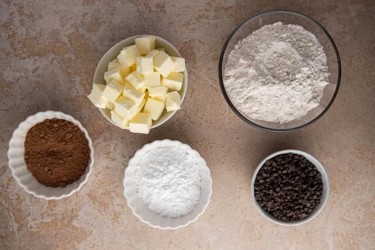  Ingredients for chocolate cookies arranged in small bowls.