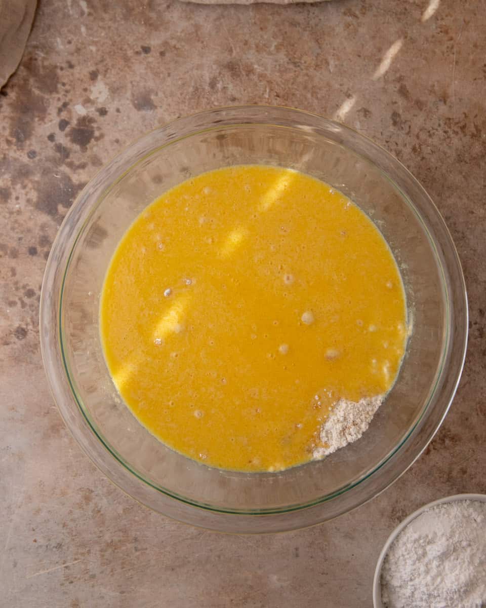 Wet ingredients mixed in bowl for cranberry orange bread batter