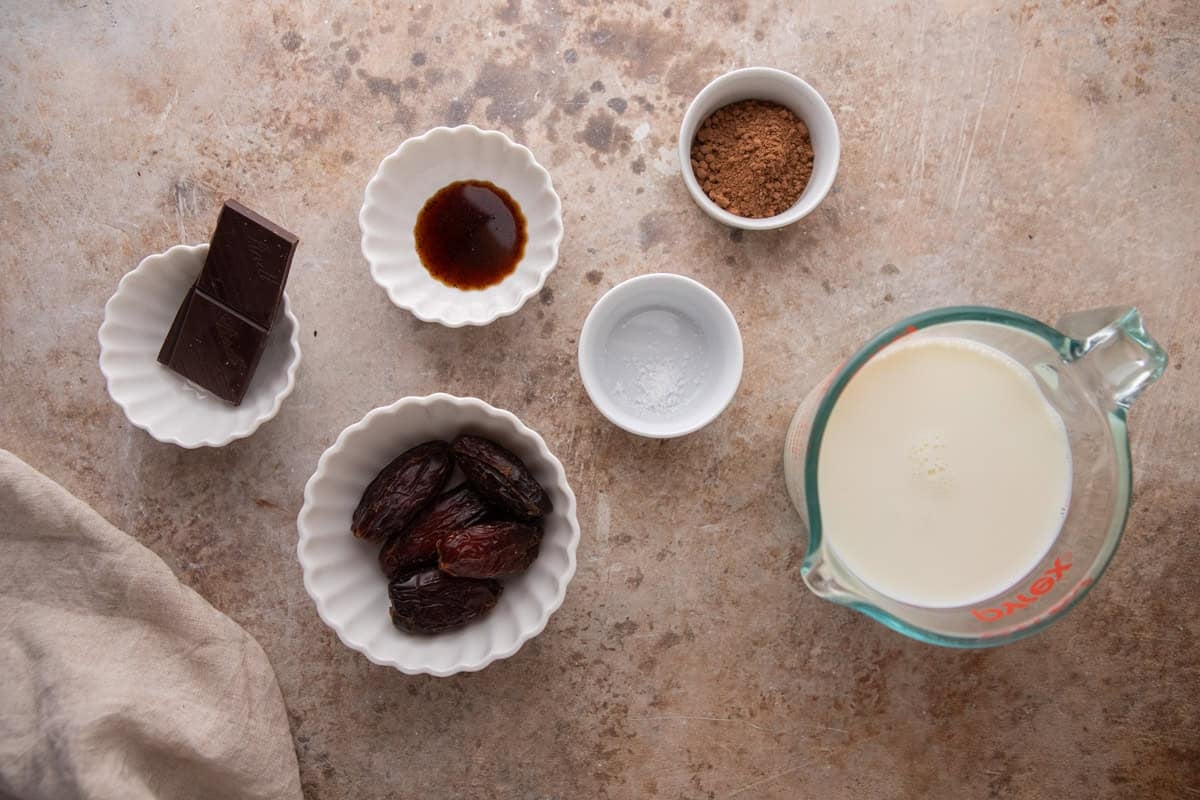 Ingredients for date sweetened hot chocolate arranged on a countertop
