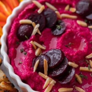 Creamy beet hummus topped with marinated beets and slivered almonds