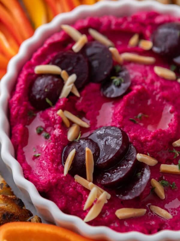 Creamy beet hummus topped with marinated beets and slivered almonds