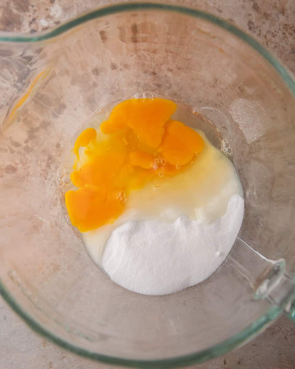 Eggs and sugar combined in a mixing bowl