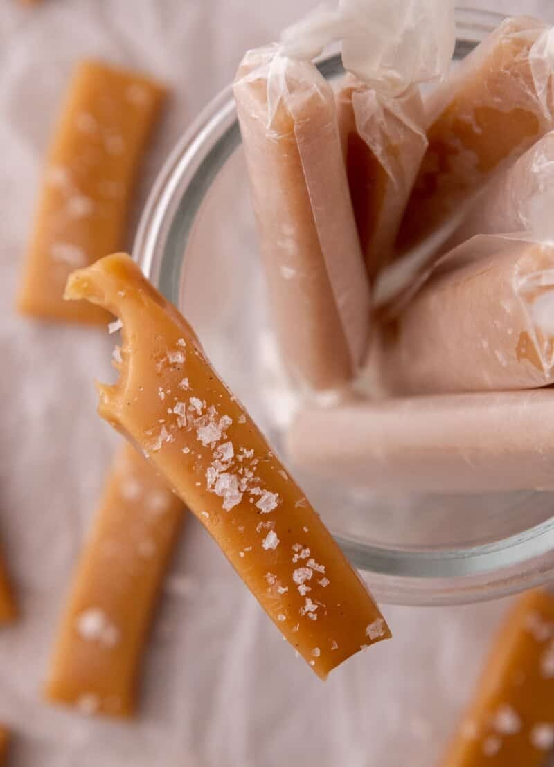 Wrapped soft caramels in wax paper with one partially eaten piece
