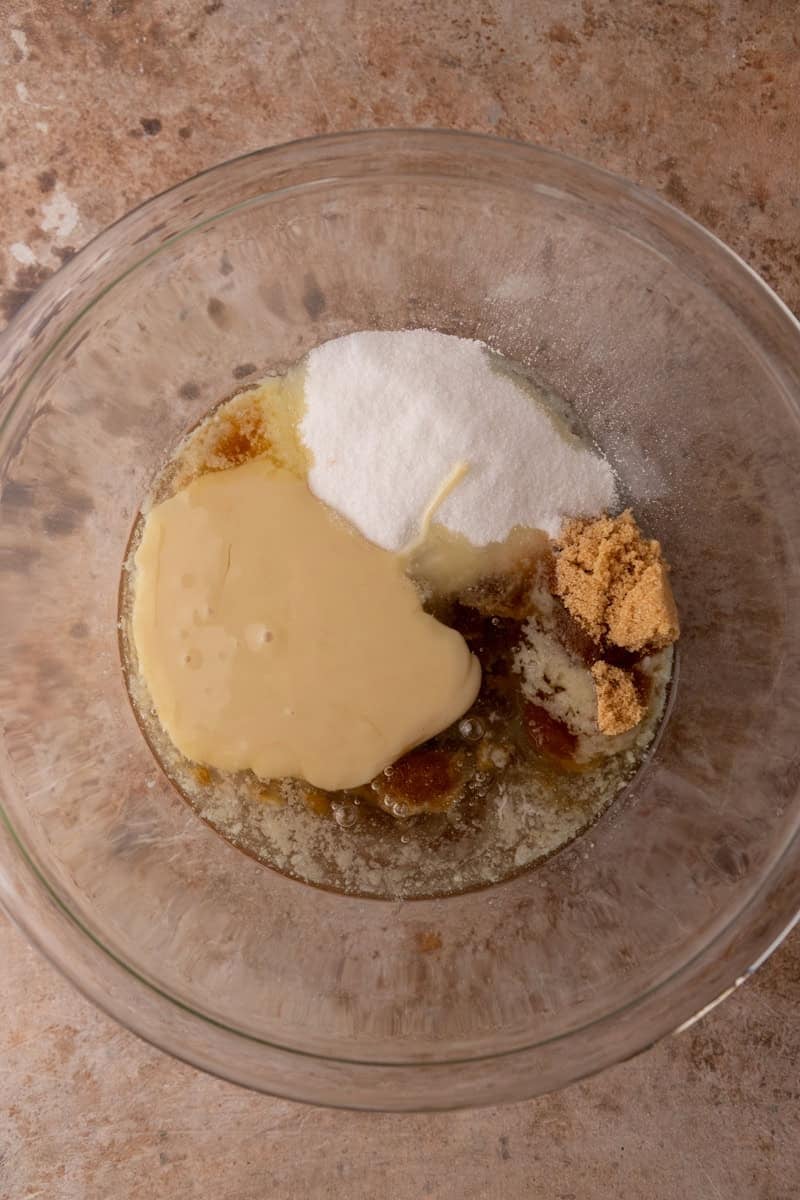 Butter, sugars, sweetened condensed milk, and corn syrup in a bowl before mixing
