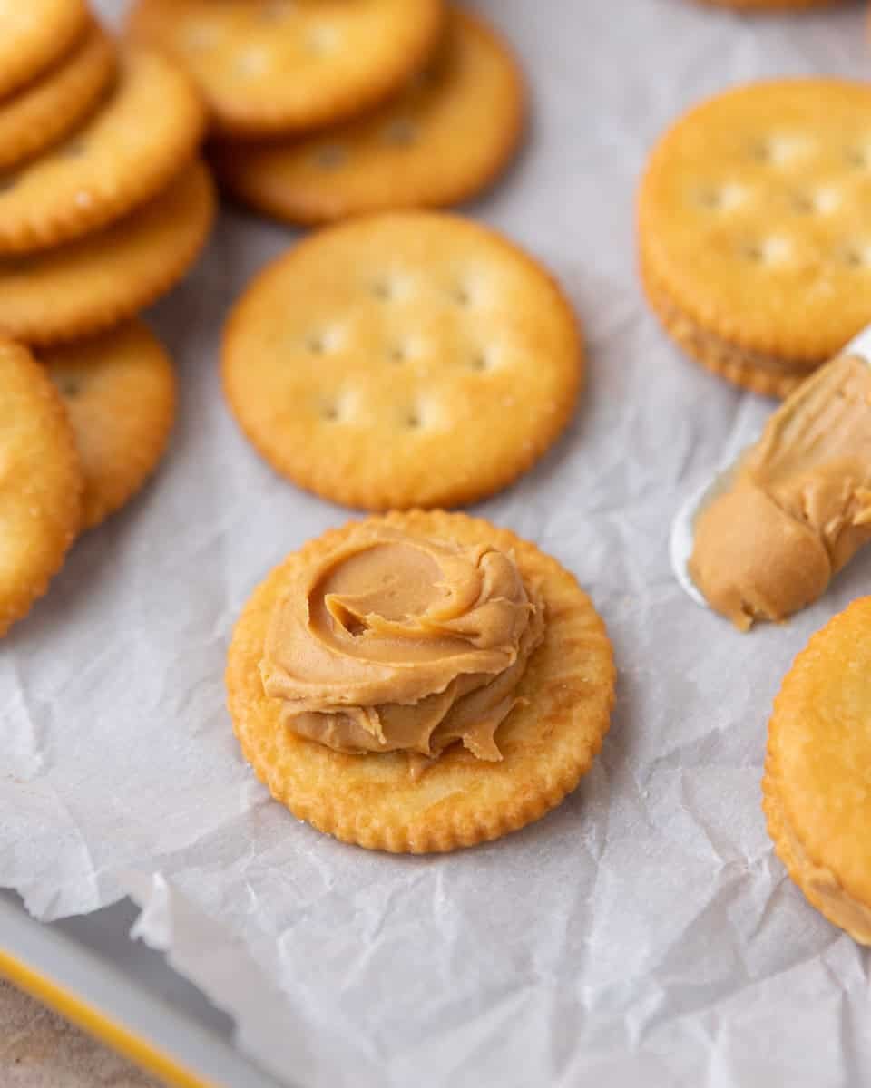 Ritz crackers topped with creamy peanut butter for peanut butter cookies