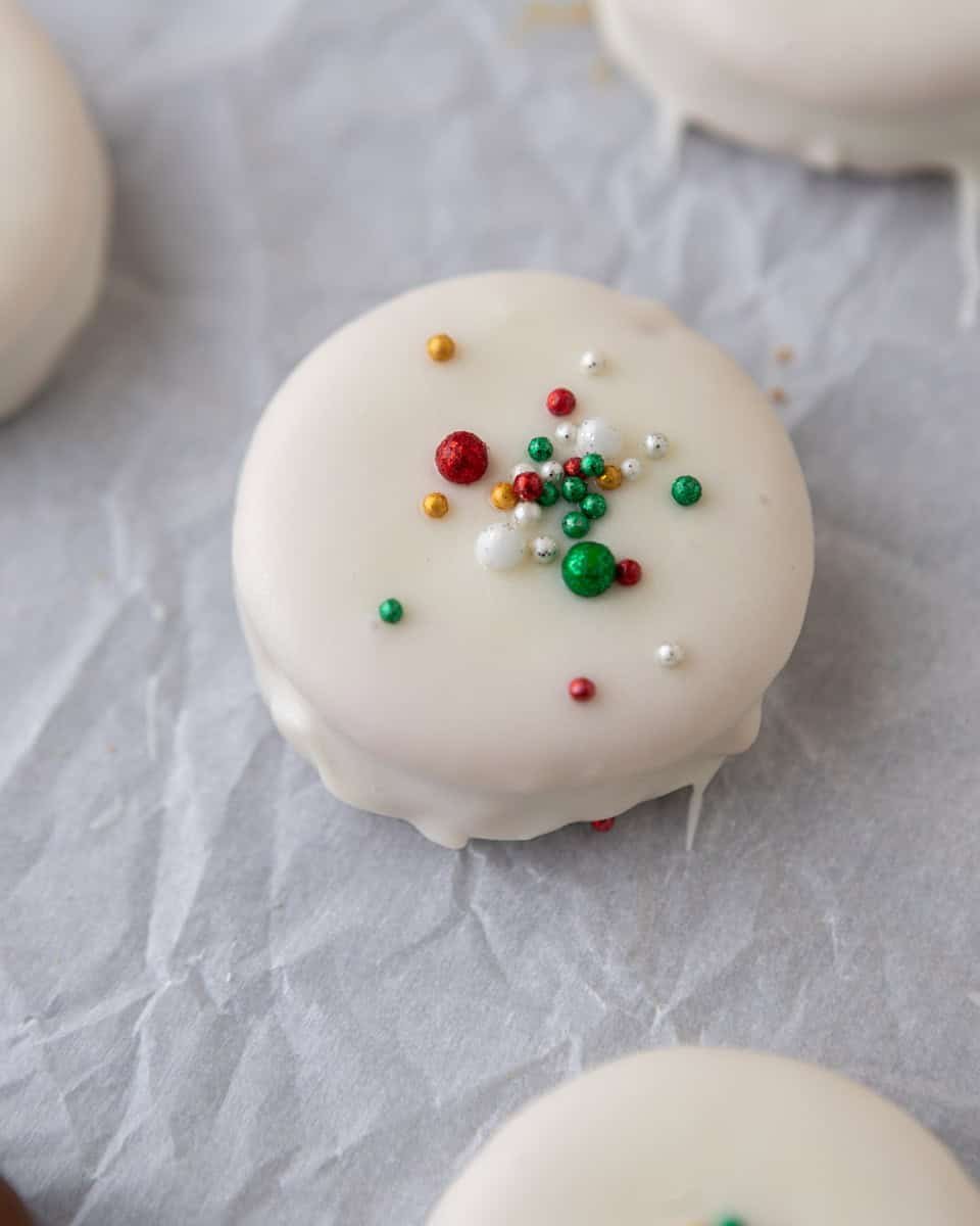 Ritz cookies dipped in white chocolate and topped with festive holiday sprinkles