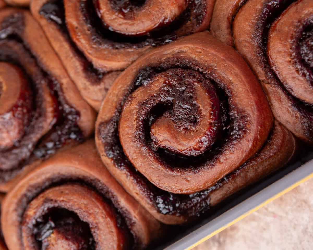 Baked Black Forest cinnamon rolls with chocolate dough and cherry filling before frosting