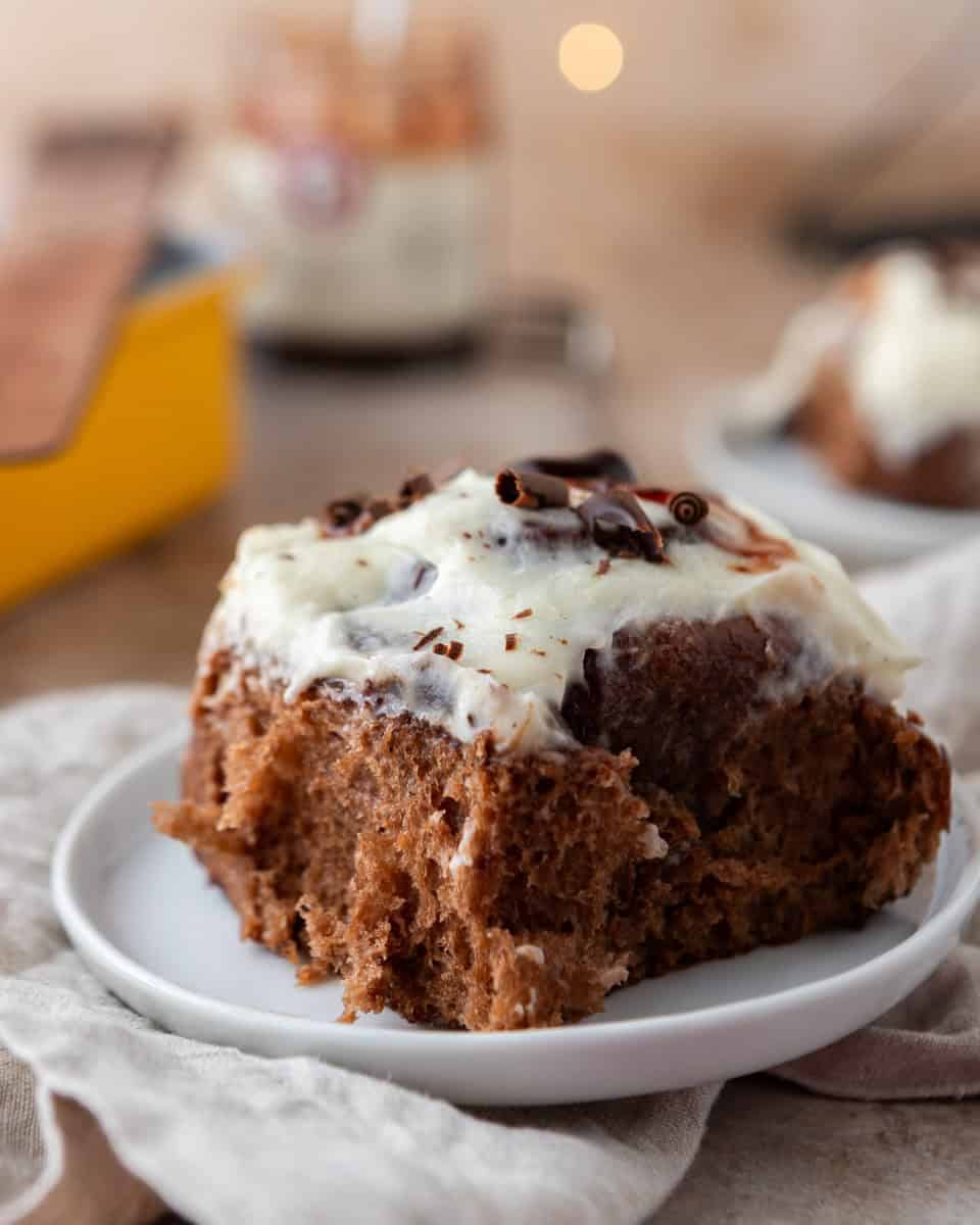 Black Forest cinnamon roll with vanilla mascarpone frosting on plate