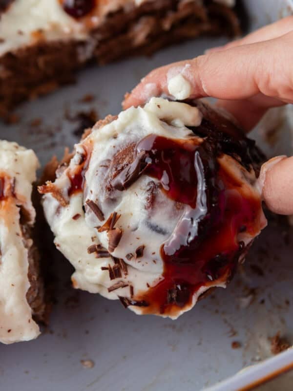 Cherry chocolate cinnamon roll pulled apart with mascarpone frosting and cherry sauce