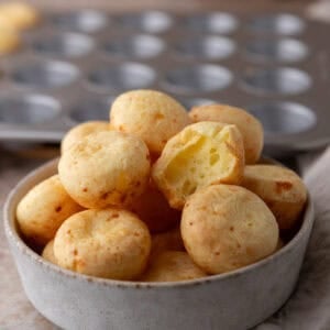 Brazilian cheese bread bites with a golden crust stacked in a bowl