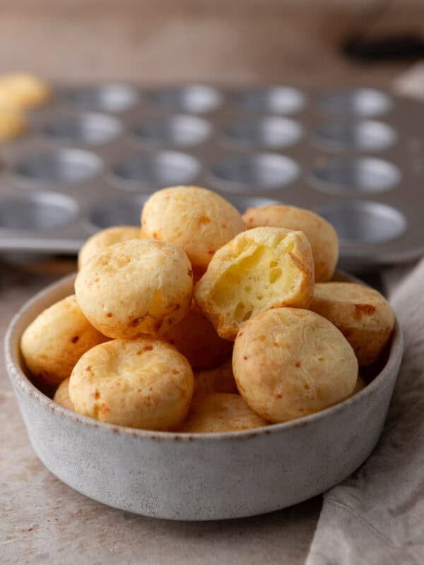 Brazilian cheese bread bites with a golden crust stacked in a bowl
