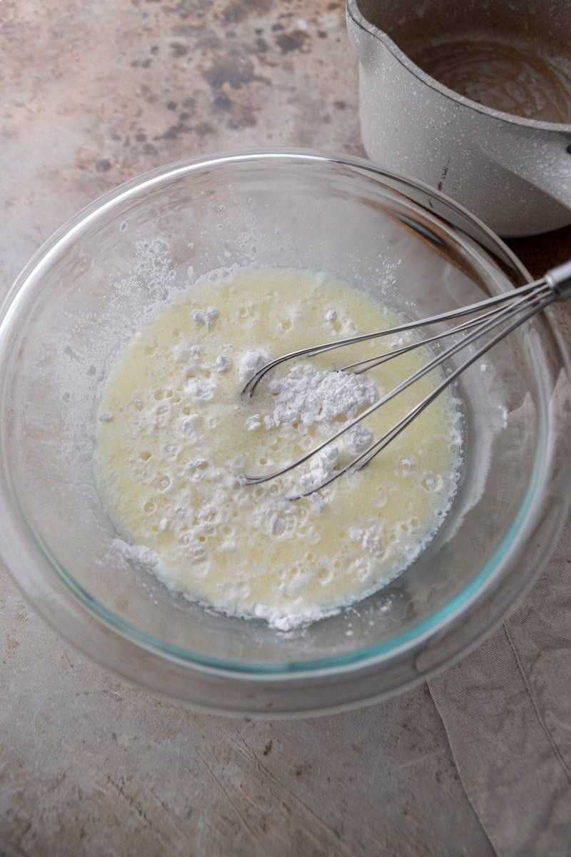 Hot milk mixture poured over tapioca flour in a bowl
