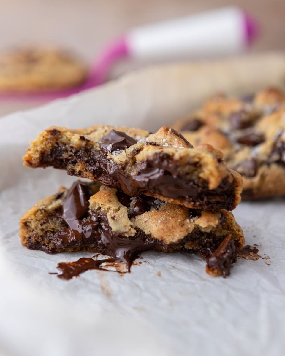 Soft cream cheese chocolate chip cookies broken open with melted chocolate and thick, gooey centers
